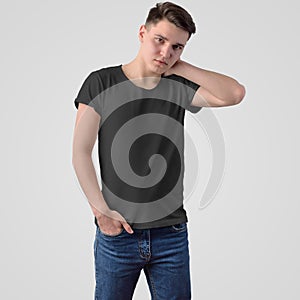 Template of a black T-shirt on a young guy in blue jeans, standing face, on a white background