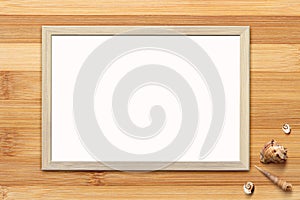 Template of blank poster in wooden frame on rustic wooden background with seashells