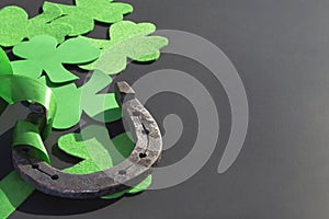 Clover and horseshoe on a dark background. St. Patrick`s Day.