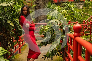 Template for a tourist travel postcard. Woman in the red dress in Monte Palace Tropical Gardens in Madeira, Funchal