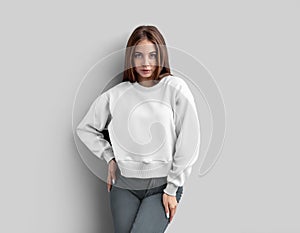 Template of a white crop shirt on a posing girl, looking straight ahead, sweatshirt  on background, front view
