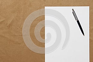 Template of white paper with pen lies on light brown cloth background. Concept of business plan and strategy. Stock