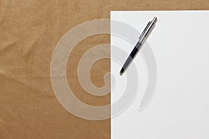 Template of white paper with pen lies on light brown cloth background. Concept of business plan and strategy. Stock