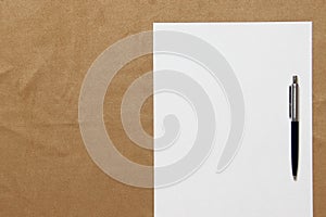 Template of white paper with pen lies on light brown cloth background. Concept of business plan and strategy. Stock