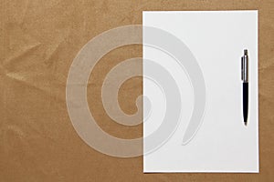 Template of white paper with pen lies on light brown cloth background. Concept of business plan and strategy. Stock