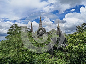 Temple in clouds with pagodas perched high on top of a rocky hill, Wat Chalerm Prakiat temple in Lampang province