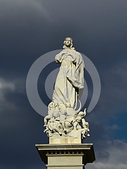 Inmaculada sculpture with dramatic dark sky photo