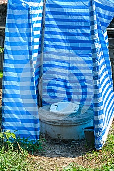 Temporary outdoor toilet plastic wall cover not confortable and dirty photo