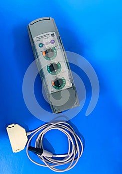 A temporary pacemaker device with connecting cable placed on a blue background