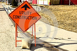 Temporary utility construction ahead sign beside a sidewalk