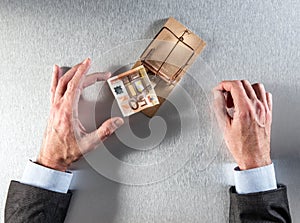 Tempted businessman hands taking a bank note for investment question
