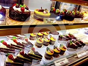 Tempting bakery fancy sweet chocolate cakes desserts mango cheesecake & fresh strawberries