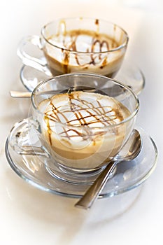 Tempting caramel latte coffees on white background