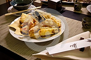 Tempura in Japanese Food Restaurant â€“ Plate with Vegetables and Shrimps Fried in Batter, Chopsticks, Ceramic Plates