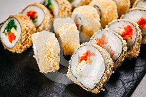 Tempura maki sushi rolls set on black slate