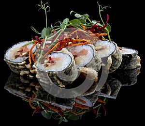 Tempura roll with salmon and tuna on glossy black background. Deep fried