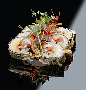 Tempura roll with salmon and tuna on glossy black background. Deep fried