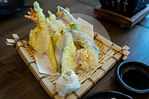 The tempura set is included in a bamboo basket beside