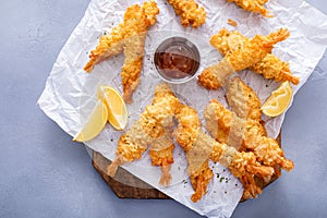 Tempura shrimp on a board served with sweet and sour sauce