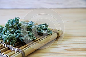 Temuras ofwild vegetable called Taranome on the raft shaped bamboo tableware