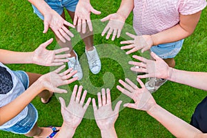 Ten arms of children in circle with palms of hands up