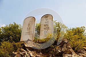 Ten Commandments List. Stone tablets on a rocky hill with carved