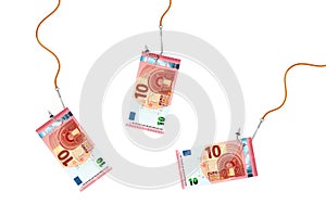 Ten euro banknotes on glossy silver metal fishing hooks on a ropes on white