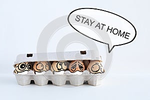 Ten funny face chicken eggs in medical masks hid at home on a white background, place for text, inscription stay home. covd-19 photo