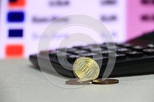 Ten Germany euro cent on obverse on white floor with black calculator on digital board of currency exchange money background.