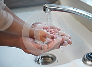 Ten out of ten for washing your hands. an unrecognisable man helping his child wash their hands in the sink at home.