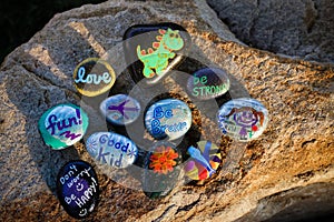 Ten painted rocks on a boulder