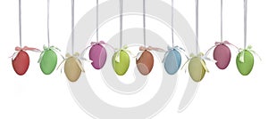 Ten plain monochrome multicoloured Easter eggs hanging on ribbons with coloured bows.