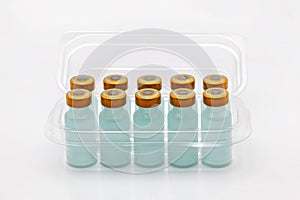 Ten vaccine bottles inside opened translucent plastic box