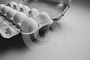 Ten white eggs in a carton package. Cardboard egg box on orange background
