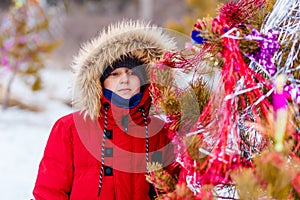 A ten-year-old boy near a Christmas tree