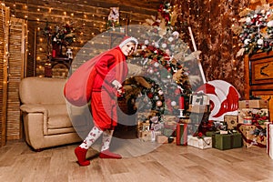 Ten-year-old boy in a red santa suit with bag of gifts for Christmas