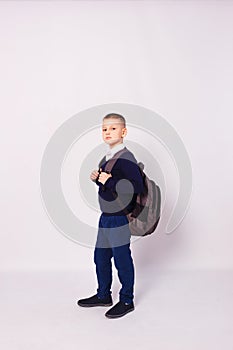 Ten-year-old boy in school uniform with backpack on his back