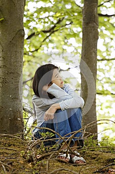 Ten year old girl sitting quietly in woods