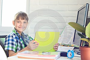 A ten-year-old girl is studying remotely at home and cheerfully looked into the frame