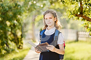 Ten-year-old schoolgirl with a book in the outdoors