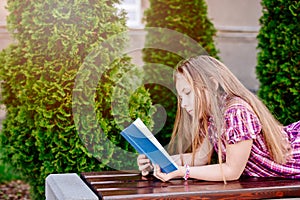 Ten years old blue eye blonde girl reading book