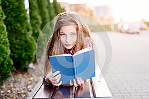 Ten years old blue eye blonde girl reading book