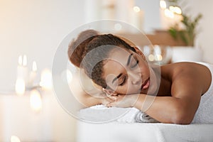 Tender african girl resting relaxing with closed eyes in spa salon.