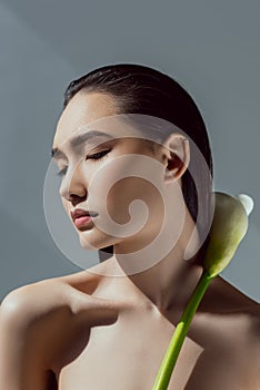 tender asian girl with closed eyes holding calla flower