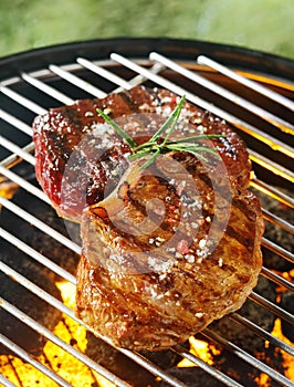 Tender beef steaks grilling over the flames