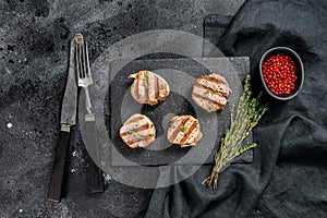 Tender boneless grilled pork chops. steak tenderloin. black background. Top view