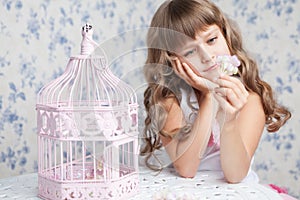 Tender dreamy romantic girl near open birdcage