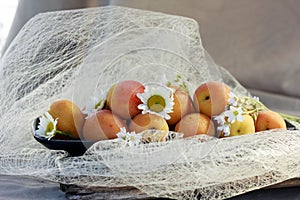 Tender fresh apricots on a black dish