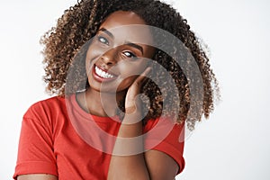 Tender friendly-looking attractive young african-american woman with curly afro hairstyle combing hair with hand gently