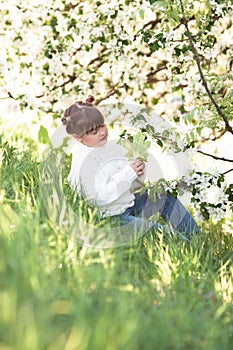 Tender girl near blooming apple tree branches